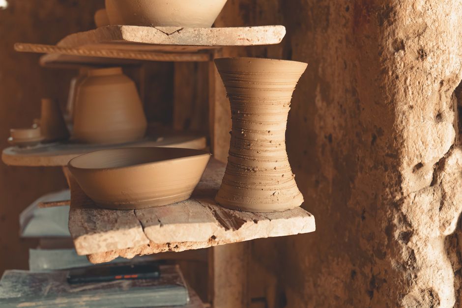 Handcrafted clay pottery displayed on rustic wooden shelves capturing the essence of traditional art.